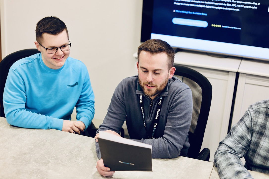 A team of marketers in a meeting looking at a piece of paper.