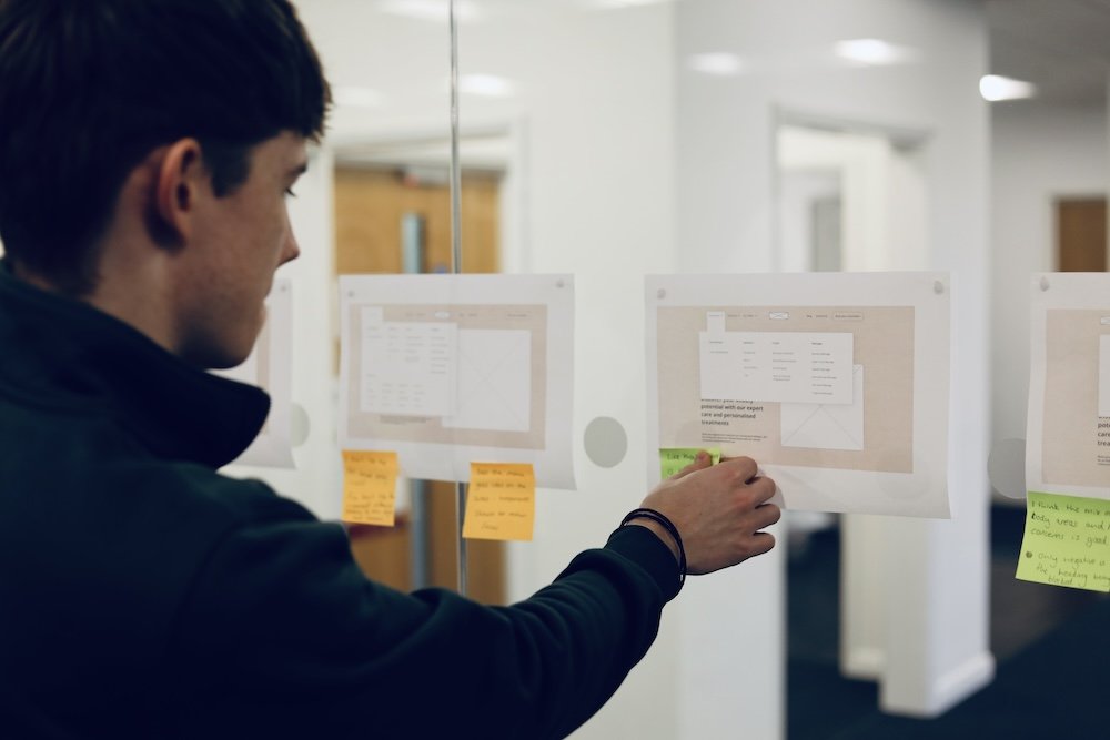 Ed Roberts, one of Damteq's UX Specialists, creating notes on different navigation menu UIs for a client website.