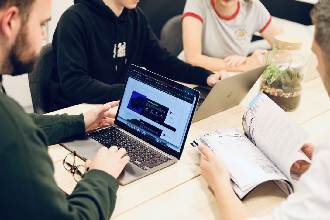 A group of marketers at Damteq working on a client growth marketing strategy on their laptops.