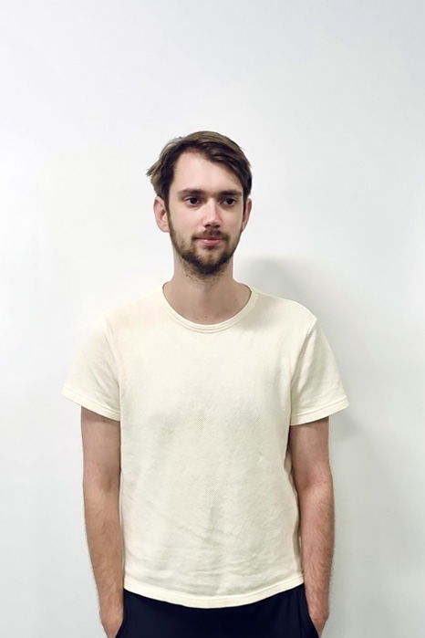 Richard Patmore, one of Damteq's Front-End Web Developers standing in front of a white wall while looking at the camera.