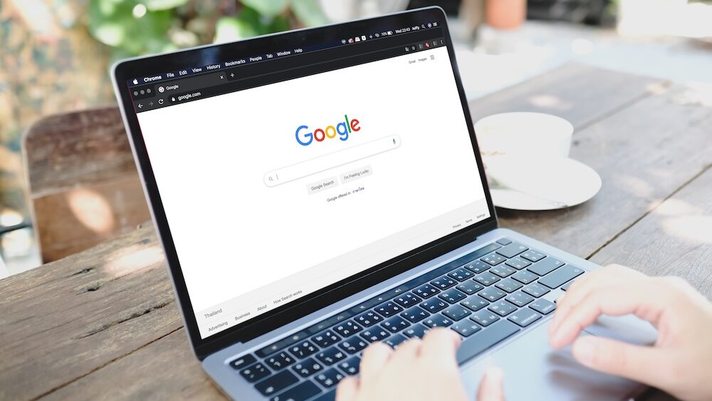 A man using Google on a laptop to learn about Consent Mode while working outside.